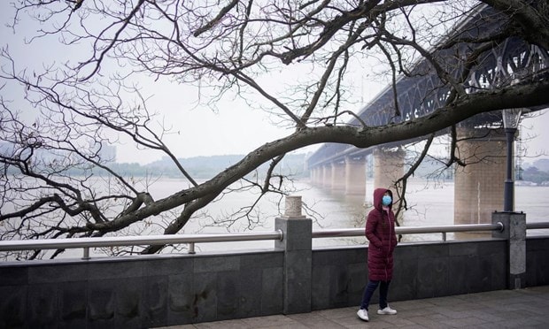 Một người phụ nữ đi bộ dưới cầu bên sông Dương Tử ở Vũ Hán. (Nguồn: Reuters)