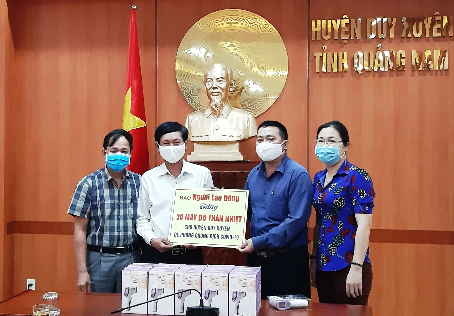 Đại diện Báo Người lao động trao tặng 20 máy đo thân nhiệt cho lãnh đạo chính quyền huyện Duy Xuyên vào sáng nay 8.4. Ảnh: H.N