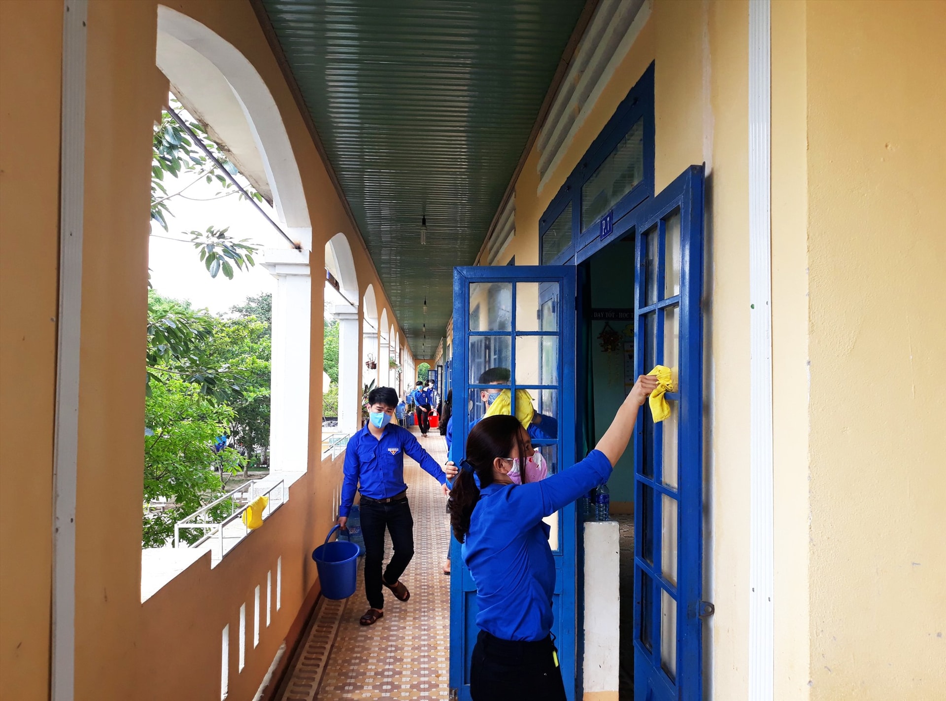 Đoàn viên, thanh niên tham gia dọn dẹp, tổng vệ sinh tại khu cách ly Trường Tiểu học Nguyễn Duy Hiệu, thị trấn Phú Thịnh, huyện Phú Ninh. Ảnh: THÁI CƯỜNG