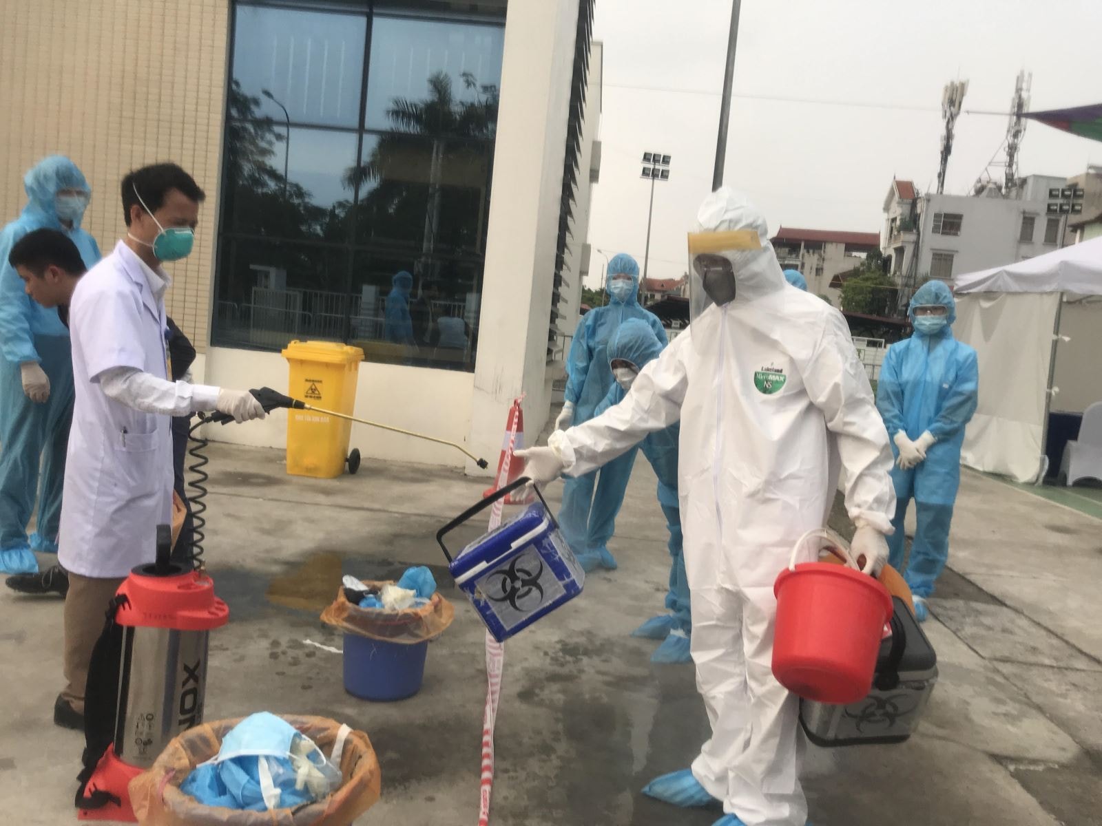 Cuối buổi làm việc, cán bộ xét nghiệm khử khuẩn thùng đựng mẫu bệnh phẩm và người để ra khỏi khu xét nghiệm.