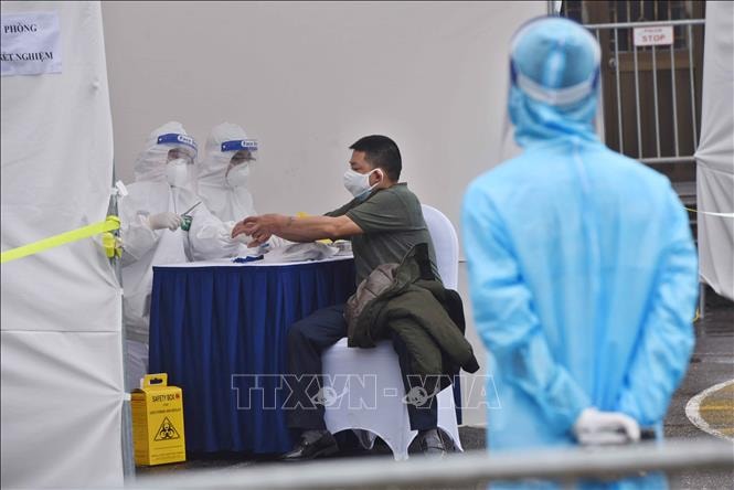Lấy mẫu xét nghiệm sàng lọc người bệnh COVID-19. Ảnh: TTXVN