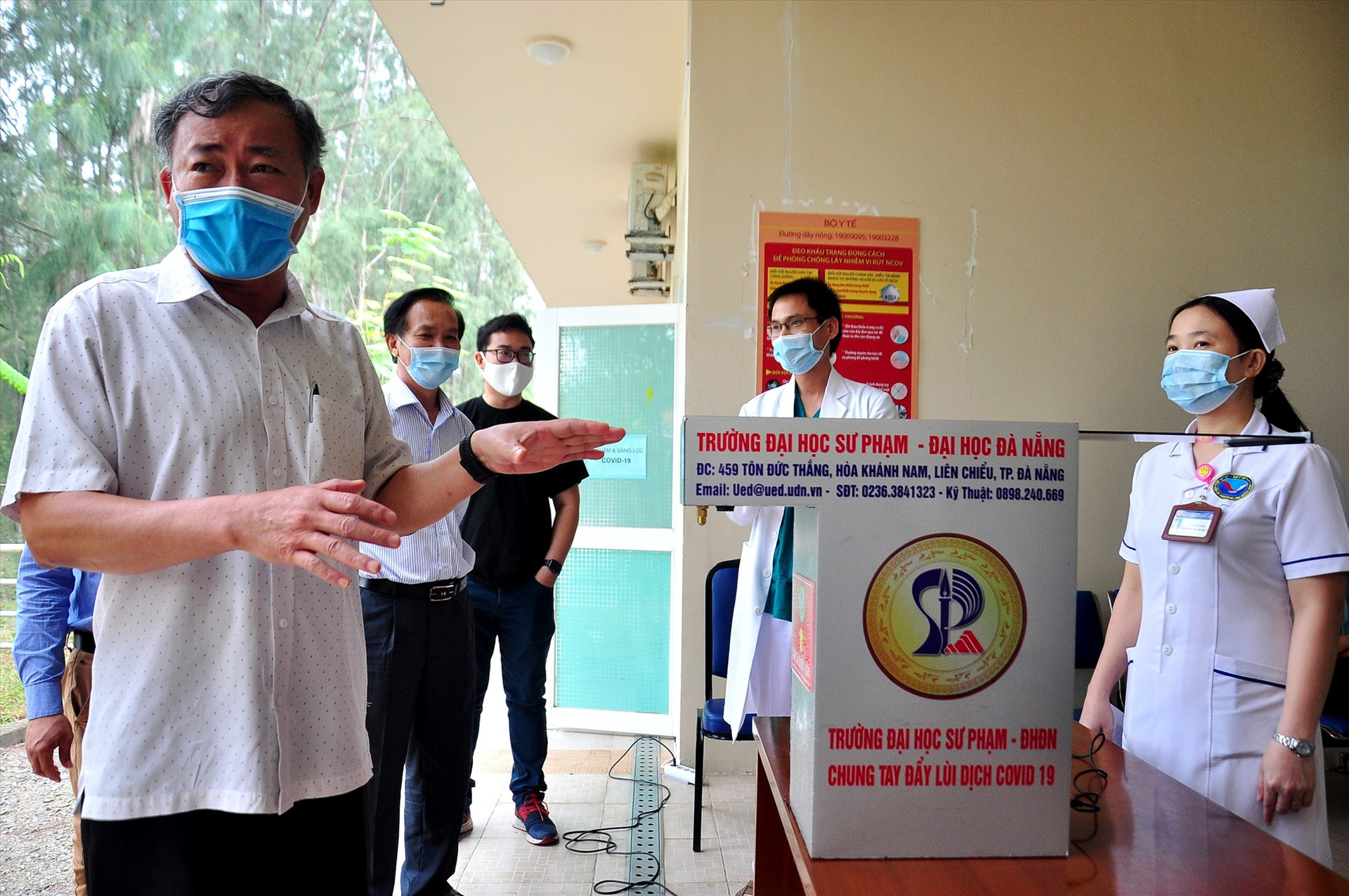 PGS.TS. Lưu Trương - Hiệu trưởng Trường ĐH Sư phạm Đà Nẵng (trái) giới thiệu về máy rửa tay sát khuẩn. Ảnh: VINH ANH