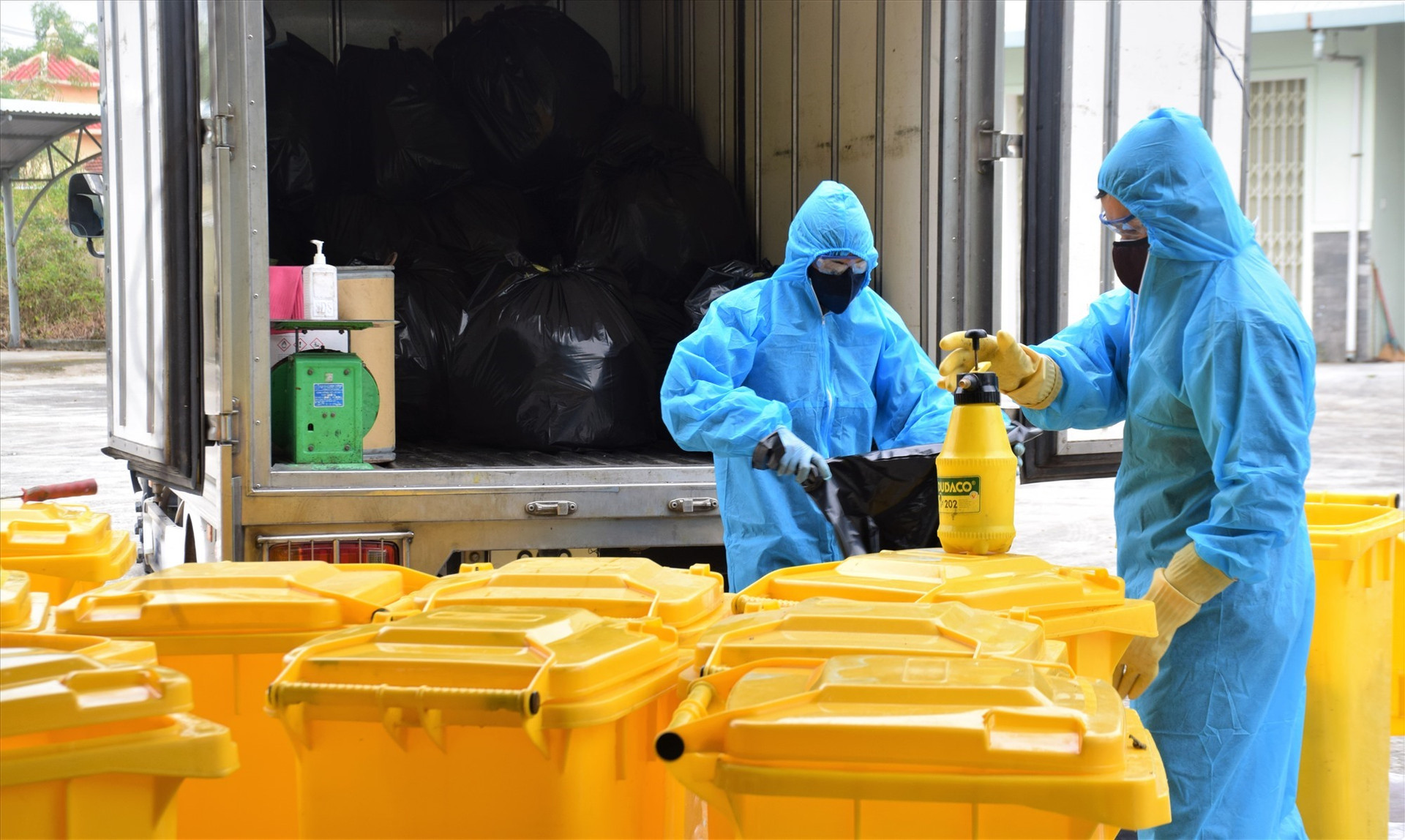 Công nhân mặc đồ bảo hộ khi thu gom rác thải tại khu cách ly tập trung Phòng khám đa khoa Khu công nghiệp Điện Nam Điện Ngọc. Ảnh: THANH THẮNG