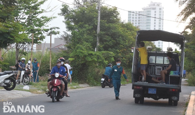 Các lực lượng chức năng đưa những người tập thể dục vi phạm quy định về biện pháp chống dịch lên xe, chở về trụ sở để xử lý vi phạm. Ảnh: HOÀNG HIỆP