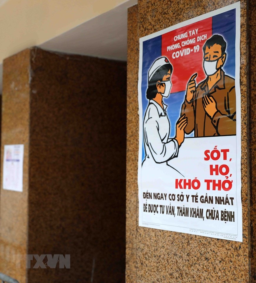 Tranh cổ động được dán ở lối vào chợ Đồng Xuân. (Ảnh: Thanh Tùng/TTXVN)