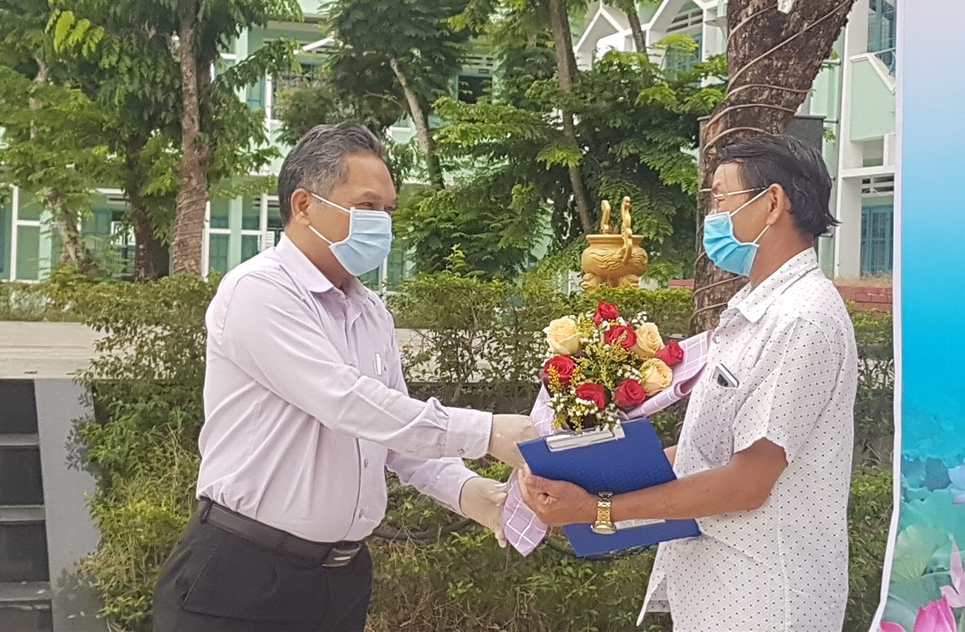 Ông Phùng Văn Huy trao hoa chúc mừng công dân hoàn thành cách ly tập trung. Ảnh: D.L
