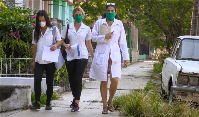 Nhân viên y tế thuộc bệnh viện El Vedado ở Havana, Cuba tới kiểm tra từng nhà dân để phát hiện các trường hợp nghi nhiễm COVID-19. Ảnh: AFP/TTXVN