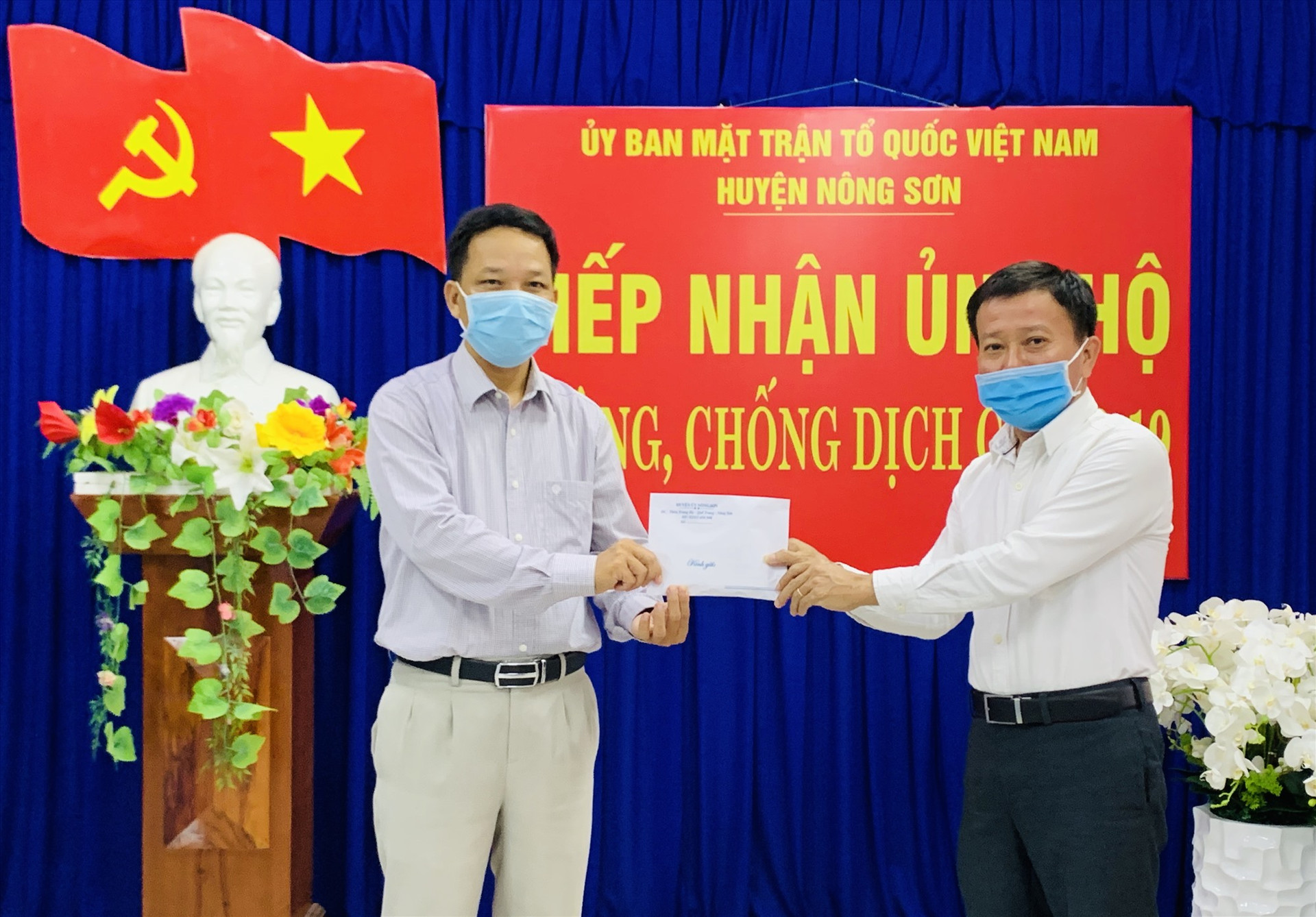 Ông Thái Bình thay mặt cho các doanh nghiệp, nhà hảo tâm trao tiền hỗ trợ cho Ủy ban MTTQ Việt Nam huyện Nông Sơn phục vụ công tác phòng, chống dịch Covid-19. Ảnh: PHAN VINH