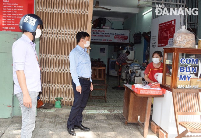 Lãnh đạo UBND phường Nam Dương nhắc nhở, hướng dẫn một chủ hộ kinh doanh ăn uống tuân thủ nghiêm túc chỉ đạo của UBND thành phố. Ảnh: HOÀNG HIỆP