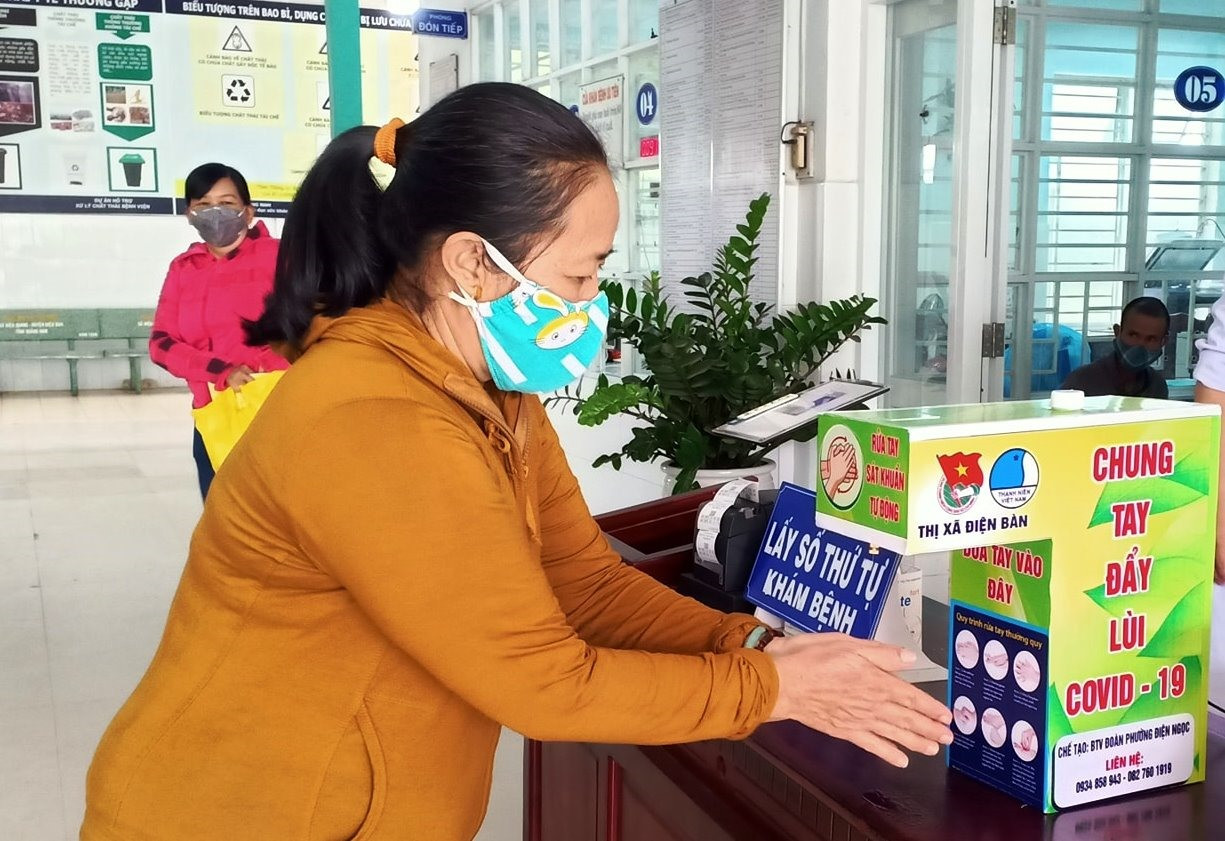 Người dân sử dụng máy rửa tay sát khuẩn tại Bệnh viện Đa khoa khu vực Quảng Nam. Ảnh: T.N