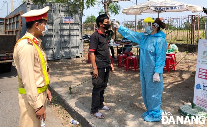 Đo thân nhiệt tại chốt kiểm soát phòng, chống Covid-19 tại cửa ngõ phía bắc thành phố vào sáng 16-4.         Ảnh: NGỌC PHÚ