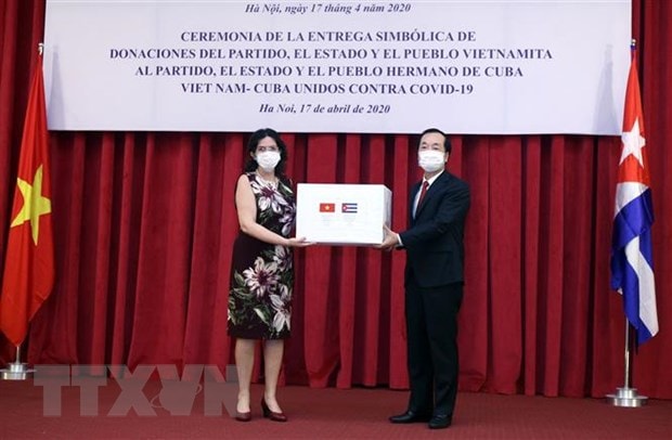 Bộ trưởng Bộ Xây dựng Phạm Hồng Hà, Thường trực Phân ban Việt Nam trong Ủy ban Liên Chính phủ hai nước trao tượng trưng 5.000 tấn gạo cho Đại sứ Cuba tại Việt Nam Lianys Torres. (Ảnh: Danh Lam/TTXVN)