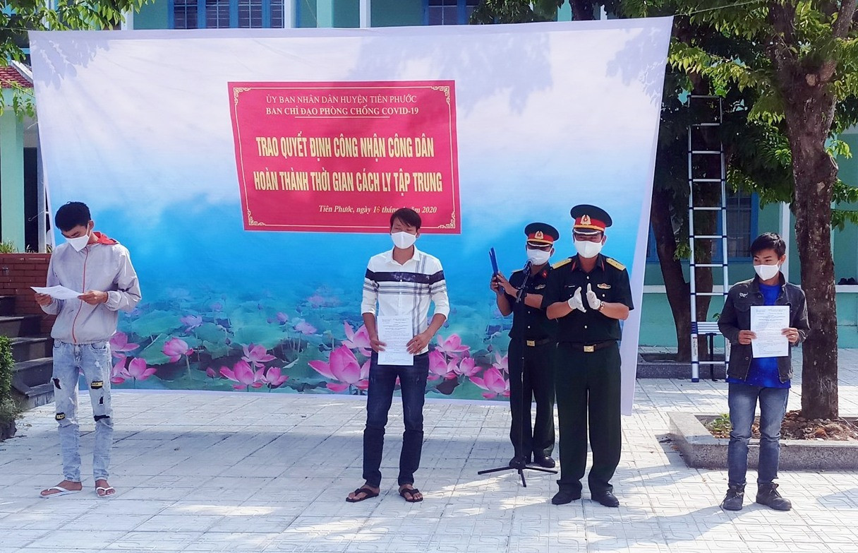 Lãnh đạo Ban CHQS huyện Tiên Phước trao quyết định hoàn thành cách ly tập trung cho 15 công dân. Ảnh: NGUYỄN HƯNG