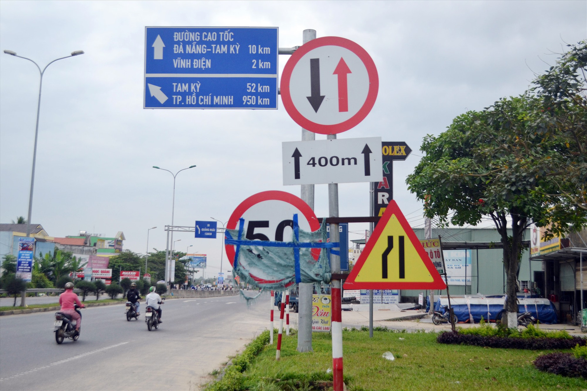 Biển hạn chế tốc độ trên quốc lộ 1 qua phường Điện An (Điện Bàn) bị che chắn mất mỹ quan. Ảnh: K.K