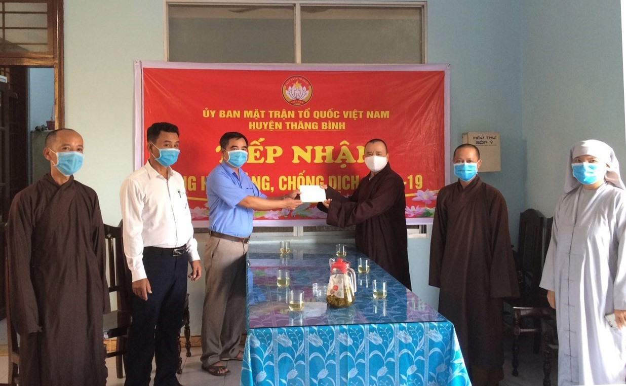Đại diện Ủy ban MTTQ Việt Nam huyện Thăng Bình tiếp nhận tiền ủng hộ từ đại diện Ban Trị sự Giáo hội Phật giáo Việt Nam huyện
