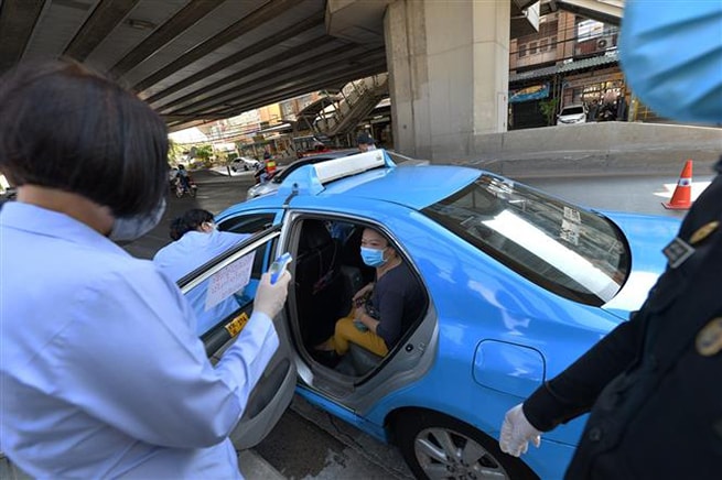 Nhân viên kiểm tra thân nhiệt của người dân tại Bangkok, Thái Lan ngày 26-3-2020 trong bối cảnh dịch Covid-19 lan rộng. Ảnh: THX/TTXVN