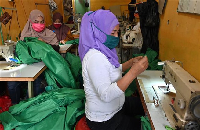 Công nhân may đồ bảo hộ y tế cá nhân và khẩu trang phòng lây nhiễm Covid-19 tại Tangerang, Indonesia, ngày 7-4-2020. Ảnh: AFP/TTXVN
