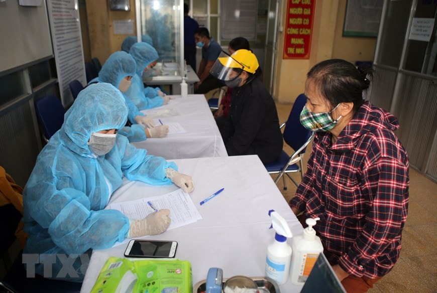 Các tiểu thương chợ đầu mối hoa quả Hoàng Mai làm thủ tục khai báo y tế trước khi lấy mẫu máu xét nghiệm Covid-19, sáng 18-4. (Ảnh: Danh Lam-TTXVN)