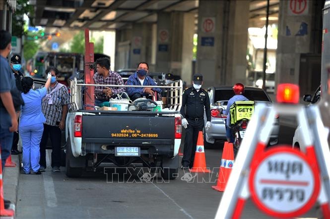 Nhân viên kiểm tra thân nhiệt của người dân tại Bangkok, Thái Lan ngày 26/3. Ảnh: THX/TTXVN