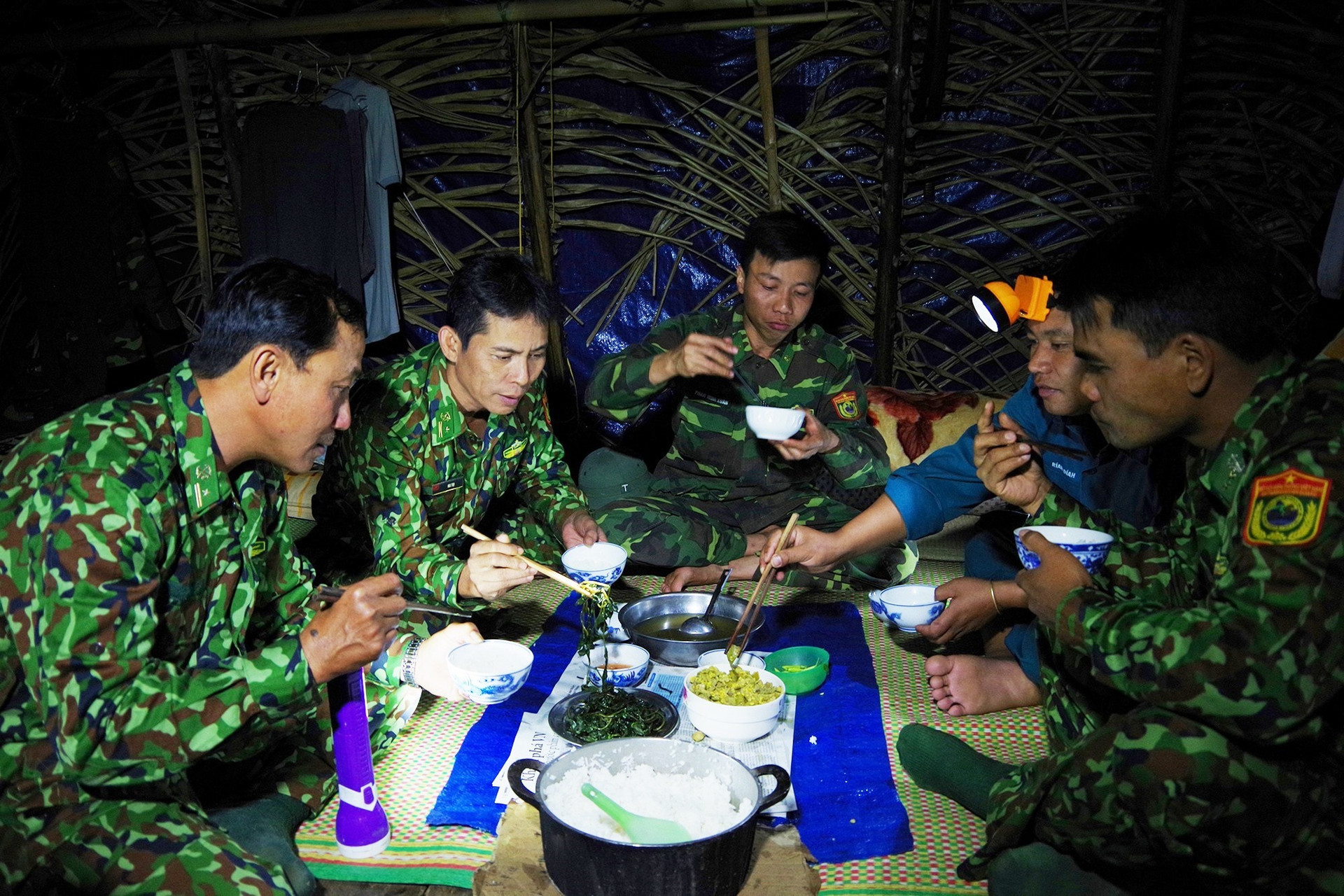 Tác giả Mai Thọ (người thứ 2 từ trái sang) đang thực hiện nhiệm vụ phòng chống dịch Covid -19 tại Tổ cắm chốt của Đồn Biên phòng Ga Ry (Tây Giang).