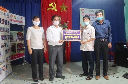 Đại diện gia đình ông Phụng trao số tiền 100 triệu ủng hộ bà con nghèo thị trấn Nam Phước.