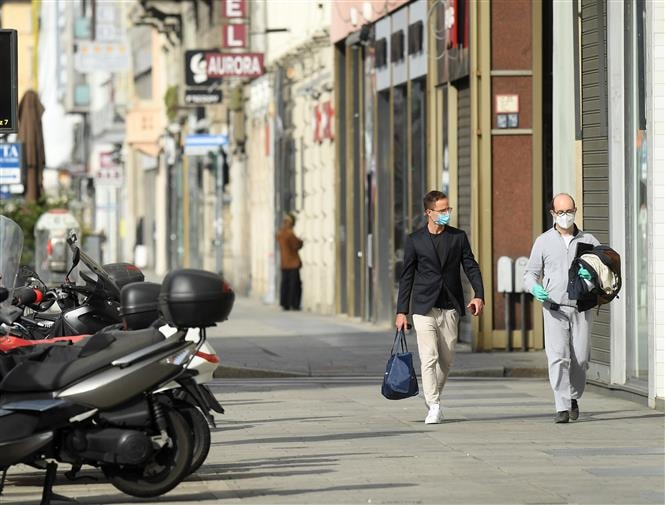 Người dân đeo khẩu trang phòng lây nhiễm COVID-19 tại Milan, Italy ngày 18/4/2020. Ảnh: THX/ TTXVN