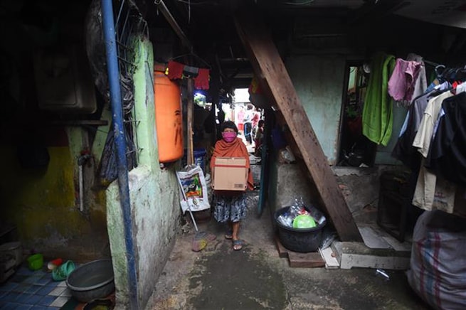 Người dân nghèo nhận nhu yếu phẩm hỗ trợ tại Jakarta, Indonesia ngày 9-4-2020. Ảnh: THX/TTXVN