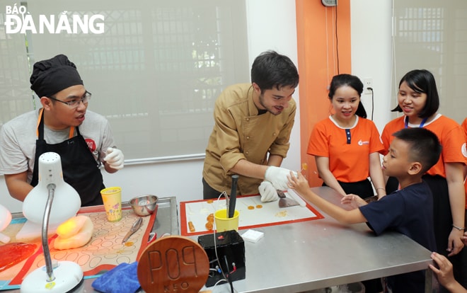 Pop Kẹo mong muốn mang đến những sản phẩm kẹo và chocolate khác biệt cho du khách và người dân địa phương. Trong ảnh: Victor Ceano (thứ hai, trái sang) người sáng lập ra Pop Kẹo đang hướng dẫn làm kẹo cho các bạn nhỏ cuối năm 2019. Ảnh: Pop Kẹo cung cấp