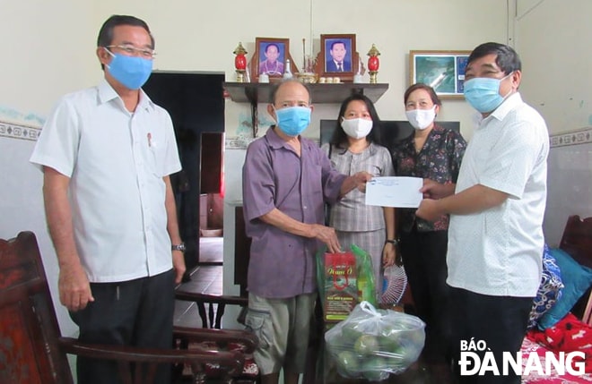 Đại diện lãnh đạo quận Liên Chiểu trao hỗ trợ cho người dân bị ảnh hưởng bởi Covid-19. Ảnh: HUỲNH LÊ