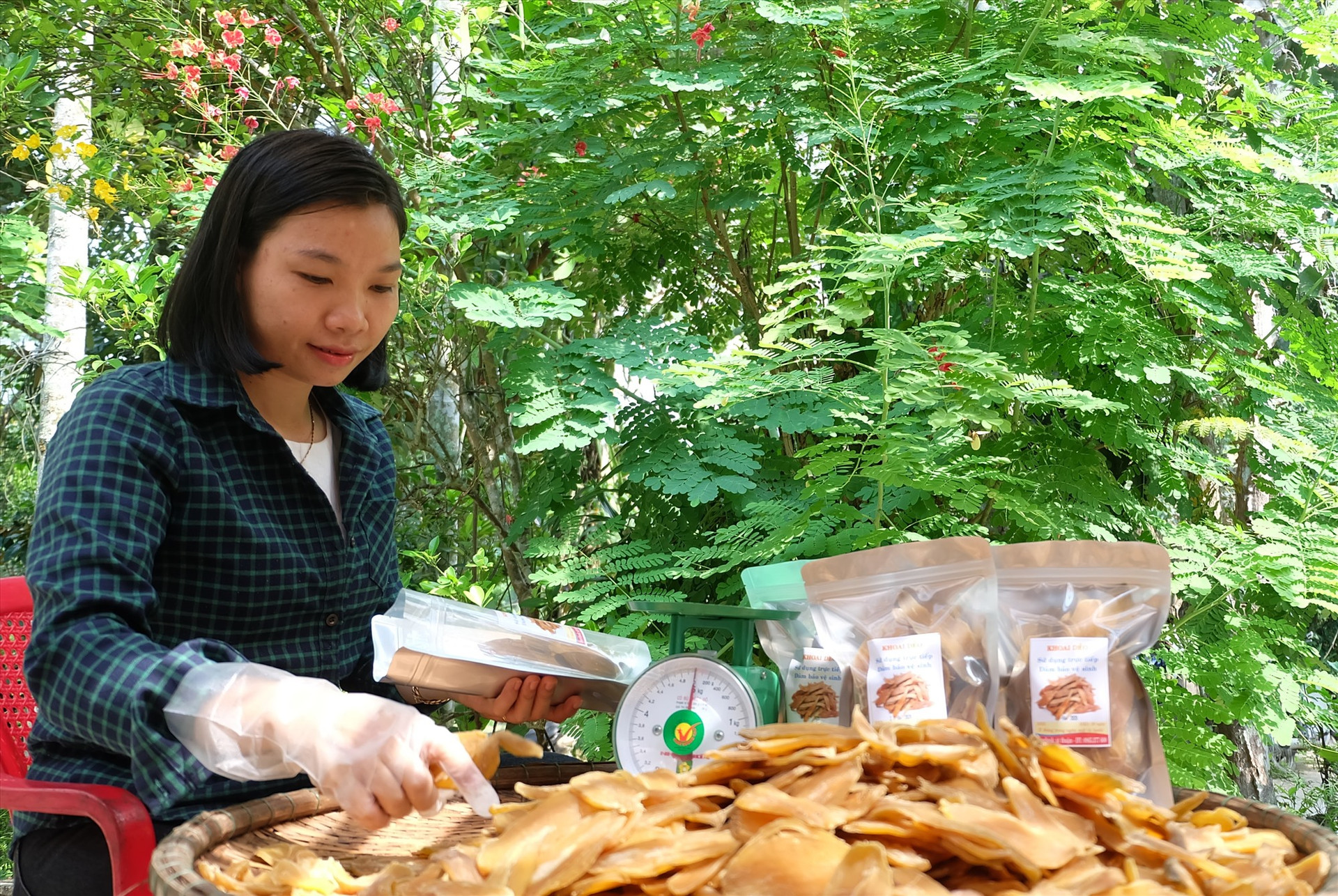 Chị Thuận đang đóng gói bao bì cho món khoai dẻo. Ảnh: M.L