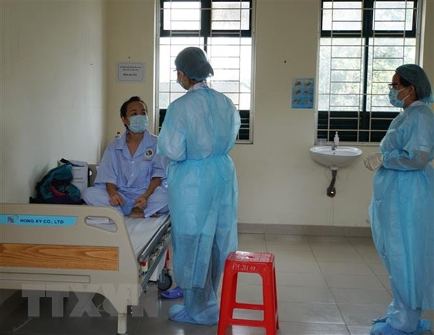 Nhân viên y tế thăm hỏi tình hình sức khỏe người cách ly tại khu cách ly Trung tâm Quận 2. (Ảnh: Đinh Hằng/TTXVN)