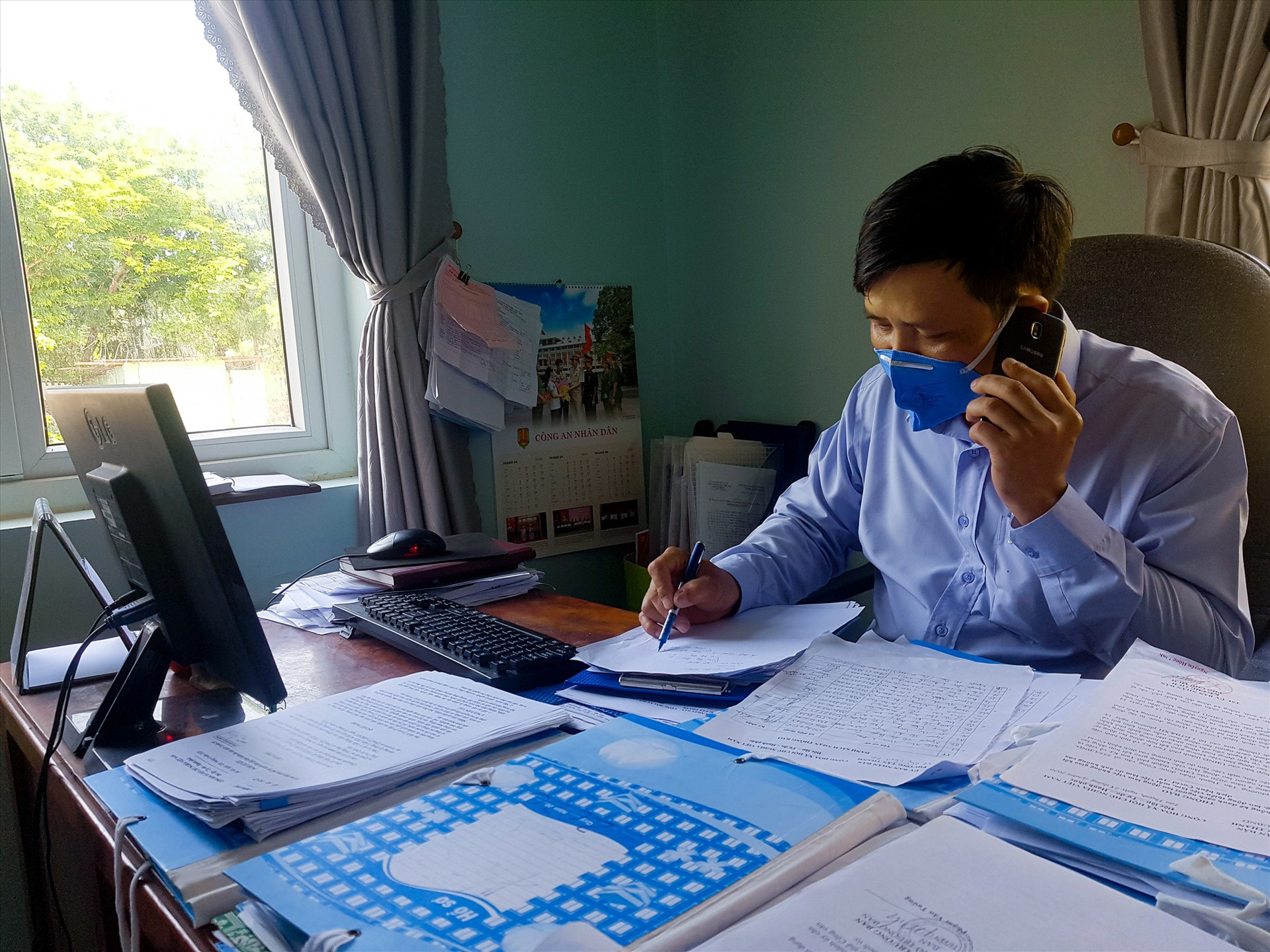 Cán bộ phường Tân Thạnh liên lạc với người dân qua điện thoại để xác minh tình trạng, thống kê sơ bộ số lượng người dân bị ảnh hưởng do dịch. Ảnh: T.C