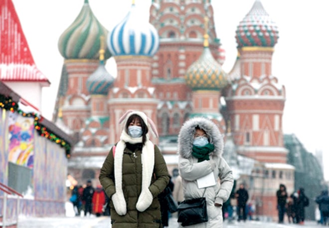 Người dân mang khẩu trang khi đi lại trên đường phố ở Moscow. Ảnh: Bloomberg