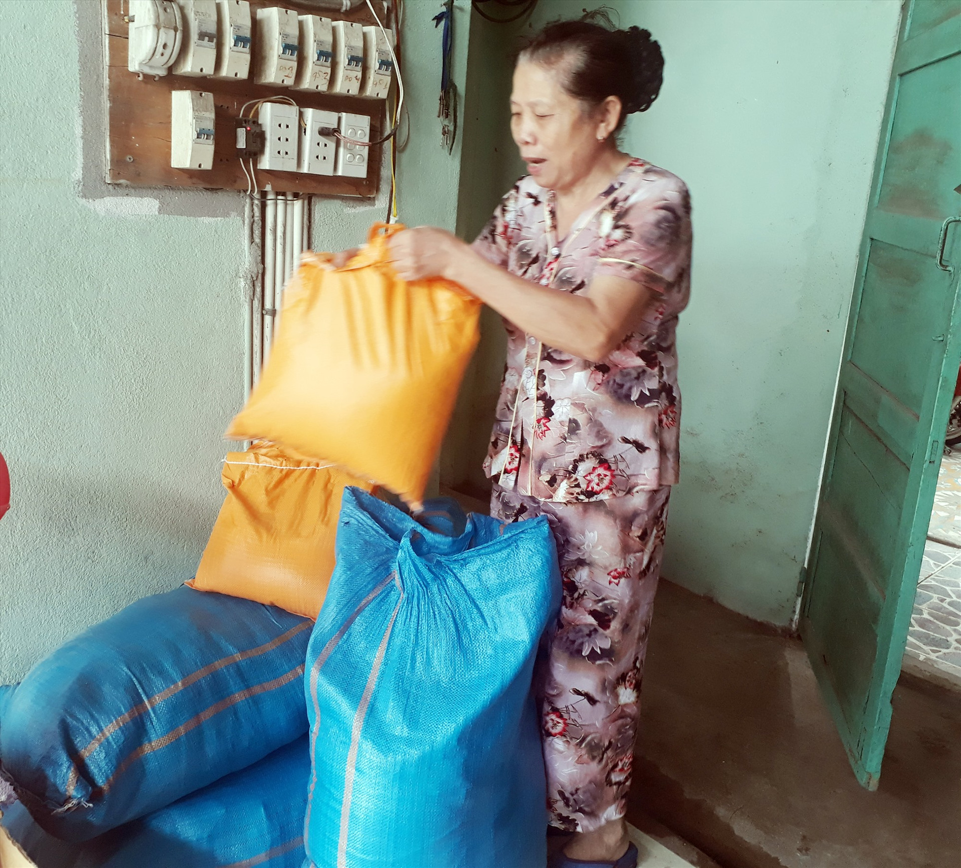 Bà Nguyễn Thị Nhạn chuẩn bị các phần gạo tặng người khó khăn. Ảnh: HUYỀN CHI