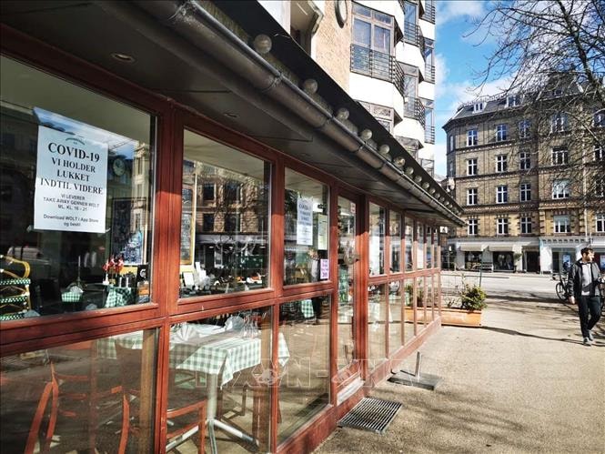 Biển thông báo chỉ bán thức ăn mang về được dán bên ngoài một nhà hàng tại Copenhagen, Đan Mạch trong bối cảnh bùng phát dịch Covid-19, ngày 19-3-2020. Ảnh: THX-TTXVN