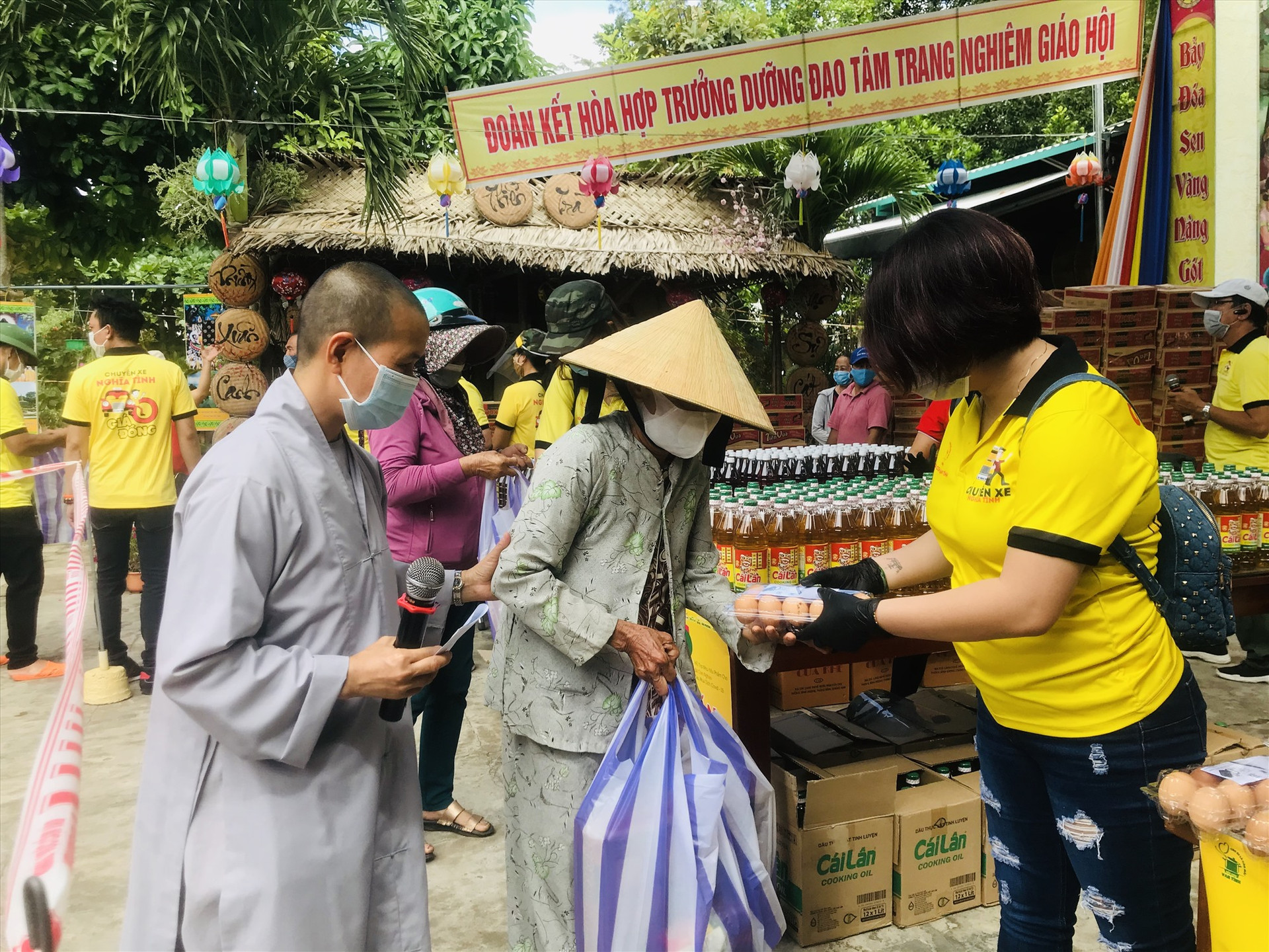 Thành viên CLB Bếp ăn Vạn Tình và Chuyến xe 0 đồng trao quà hỗ trợ người dân tại Siêu thị 0 đồng (xã Tam Phú, Tam Kỳ). Ảnh: C.N