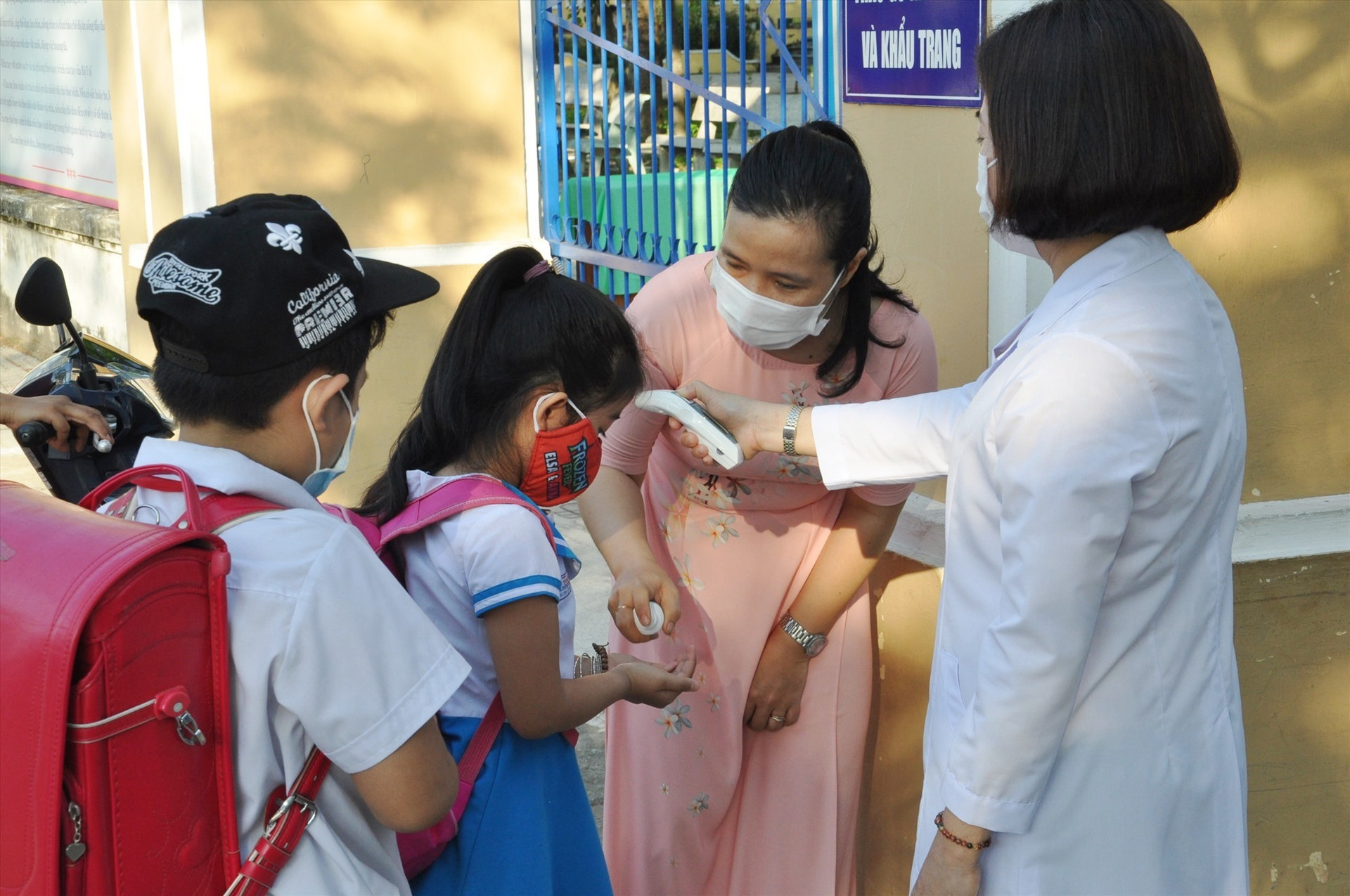 Trường Tiểu học Trần Quốc Toản (Tam Kỳ) tổ chức đo thân nhiệt và khử khuẩn cho HS từ hơn 6 giờ sáng tại cổng trường. Ảnh: X.P