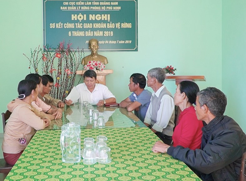 BQL rừng phòng hộ Phú Ninh làm việc với các hộ dân lấn chiếm đất rừng phòng hộ, yêu cầu họ cam kết trả đất cho Nhà nước. Ảnh: PHAN VINH