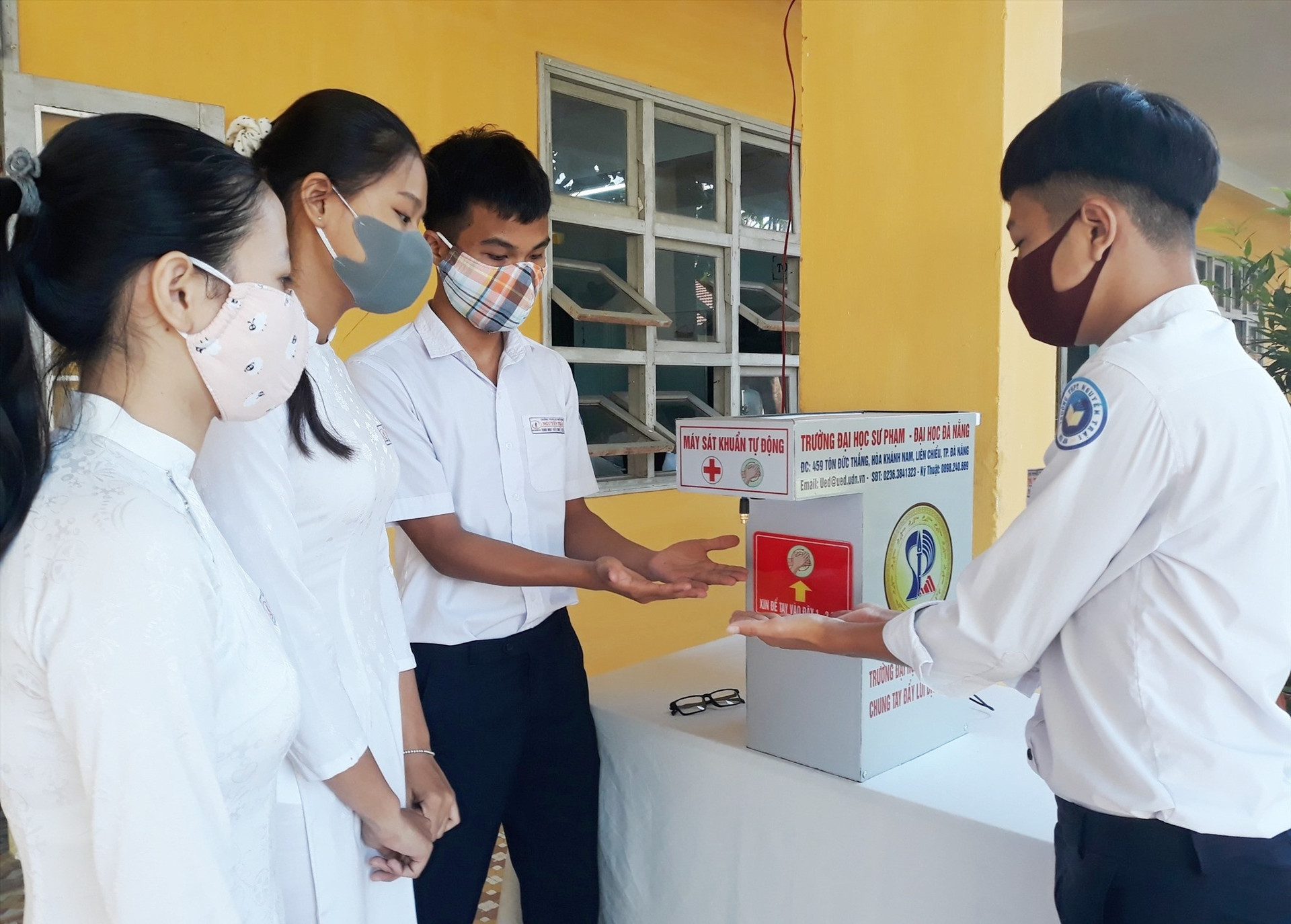 Học sinh Trường THPT Nguyễn Trãi sát khuẩn tay trước khi vào lớp học. Ảnh: C.H.