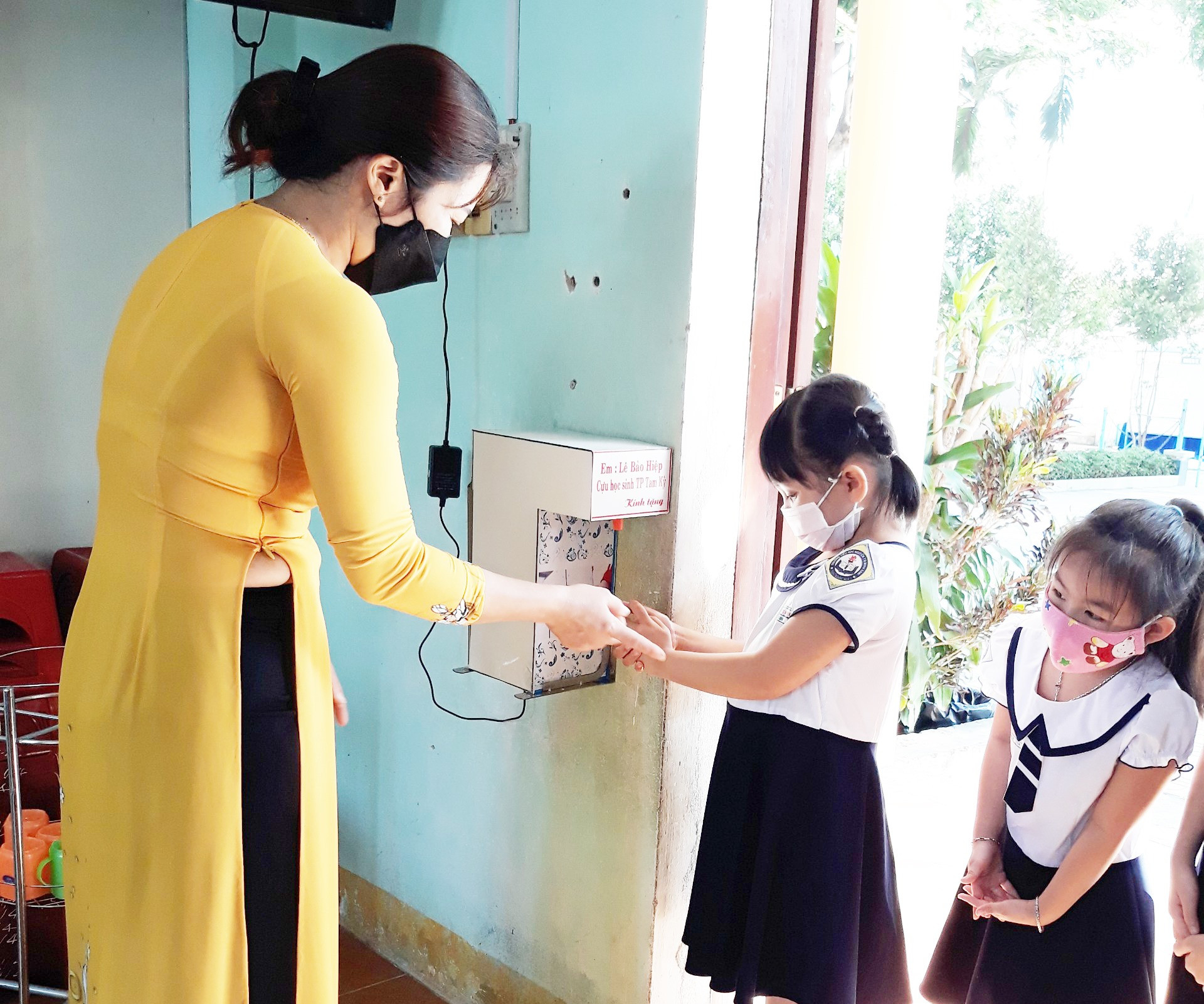 Học sinh lớp 1 Trường Tiểu học Nguyễn Thị Minh Khai (Tam Kỳ) sử dụng máy rửa tay cảm ứng do Lê Bảo Hiệp tặng. Ảnh: G.V