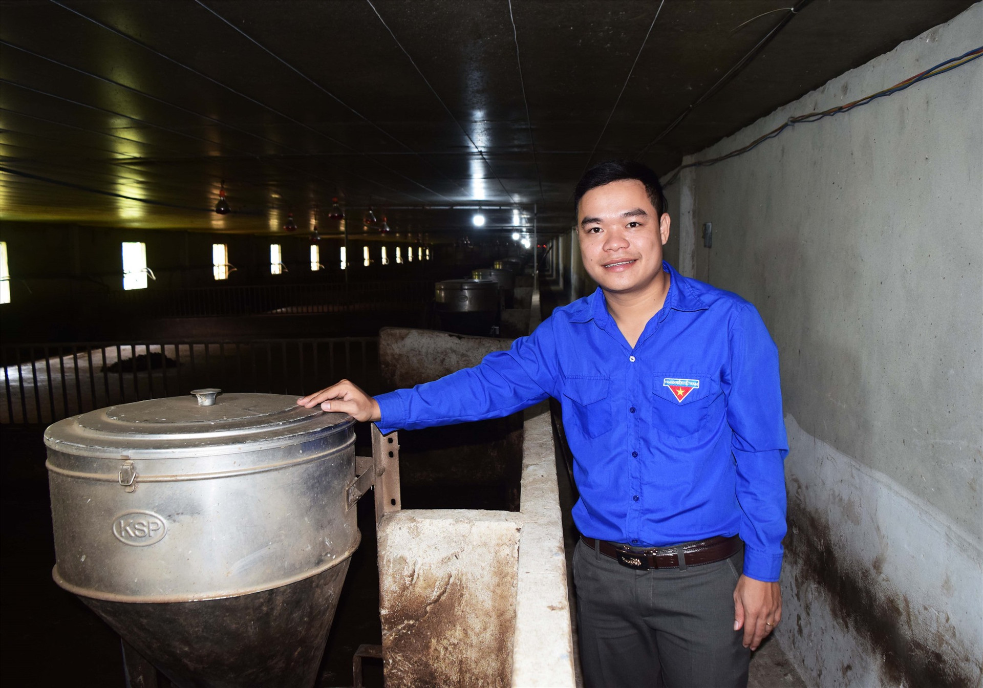 Anh Phan Văn Minh bên trong hệ thống chăn nuôi lợn khép kín, đạt tiêu chuẩn của công ty C.P Việt Nam. Ảnh: THÁI CƯỜNG
