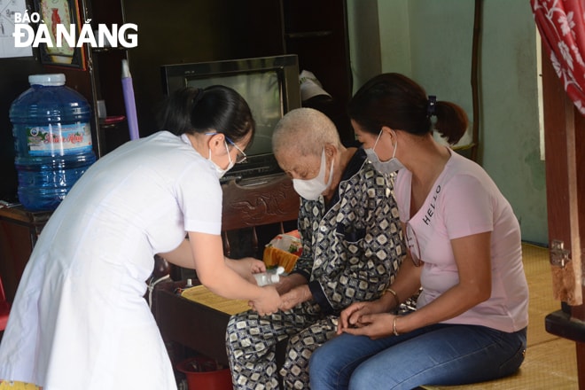 Bác sĩ thực hiện sát khuẩn tay cho người bệnh trước khi thăm khám.Ảnh: LAM PHƯƠNG