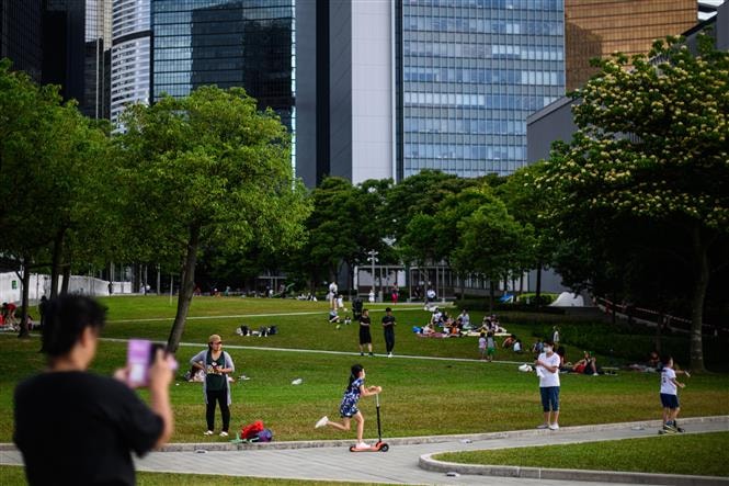 Người dân dạo chơi trong công viên Tamar ở Hong Kong, Trung Quốc ngày 5/5/2020, khi các biện pháp giãn cách xã hội do COVID-19 được nới lỏng. Ảnh: AFP/ TTXVN