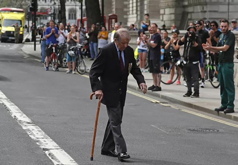 Người dân vỗ tay khi một cựu binh Thế chiến 2 đi qua đường sau 2 phút tưởng niệm ở Whitehall, London, ngày 8/5.