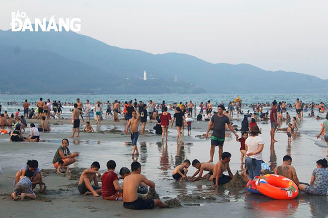 Hàng nghìn người dân đã đến tắm giải nhiệt cái nóng được dự đoán cao nhất 34 độ từ 16 giờ chiều. Ảnh XUÂN DŨNG