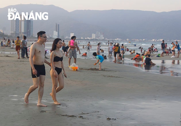 Đôi bạn trẻ đi dạo trên bãi biển. Ảnh XUÂN DŨNG