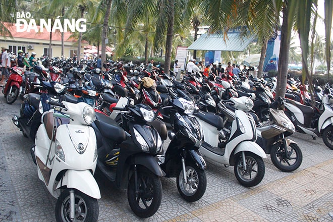Các bãi tắm nước ngọt đông đúc người đến gửi xe, tắm biển. Giá vé gửi xe máy, tắm nước ngọt là 5.000đ/lượt. Ảnh XUÂN DŨNG