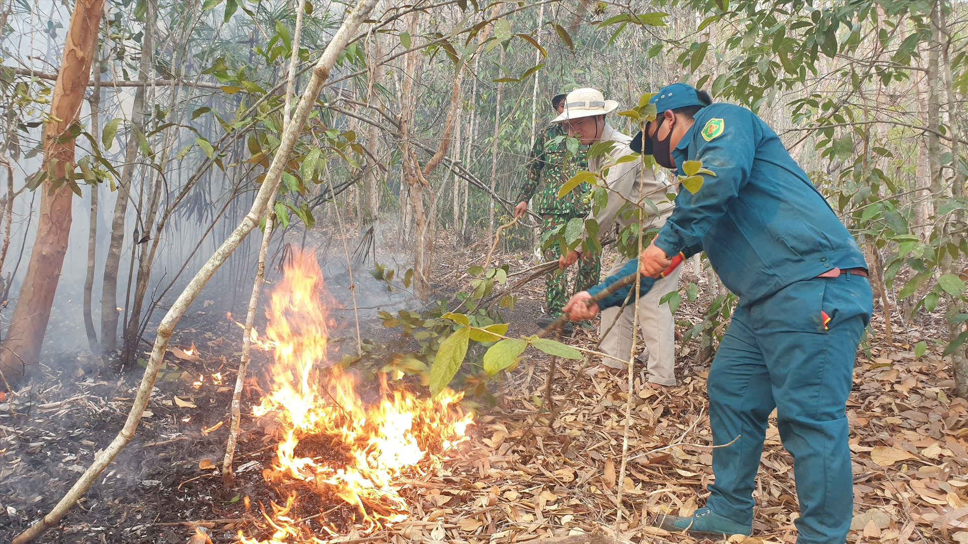 Lực lượng chức năng tiến hành khống chế đám cháy trong rừng phòng hộ Đông Giang. Ảnh: NGUYỄN THANH CHUNG