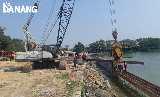 Dự án cải tạo cụm nút phía tây cầu Trần Thị Lý là công trình có ý nghĩa quan trọng nhằm giải quyết tình trạng ùn tắc giao thông, phát triển kinh tế - xã hội. TRONG ẢNH: Triển khai đóng cọc bê-tông kè bờ sông tuyến đường sau nhà hàng tiệc cưới. Ảnh: THÀNH LÂN