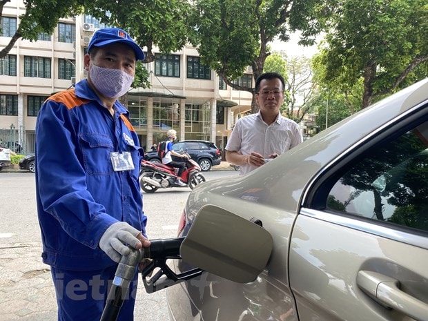 Nhân viên Petrolimex đang bán xăng cho khách hàng. (Ảnh: Đức Duy/Vietnam+)